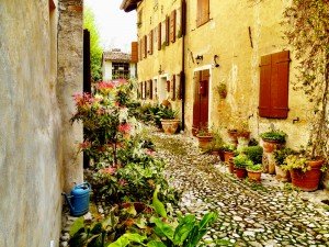 Cosa vedere vicino a Portogruaro: 5 borghi da non perdere Vicolo acciottolato con fiori e case in pietra nel borgo di Cordovado, vicino a Portogruaro